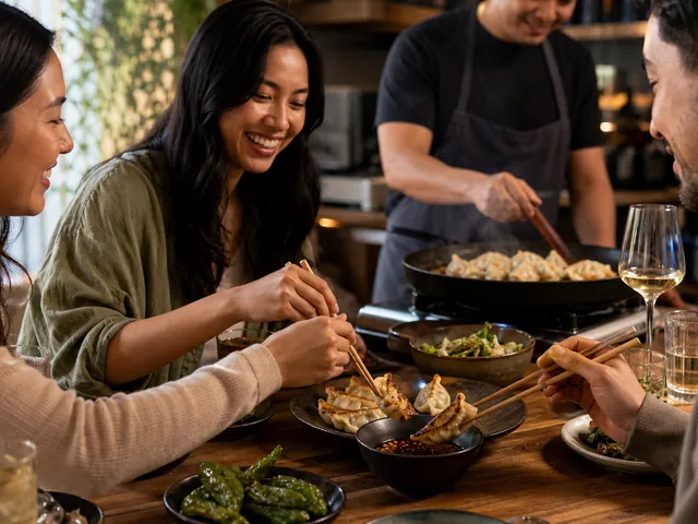 Friends sharing dumplings with smoky tamarind crispy chili sauce