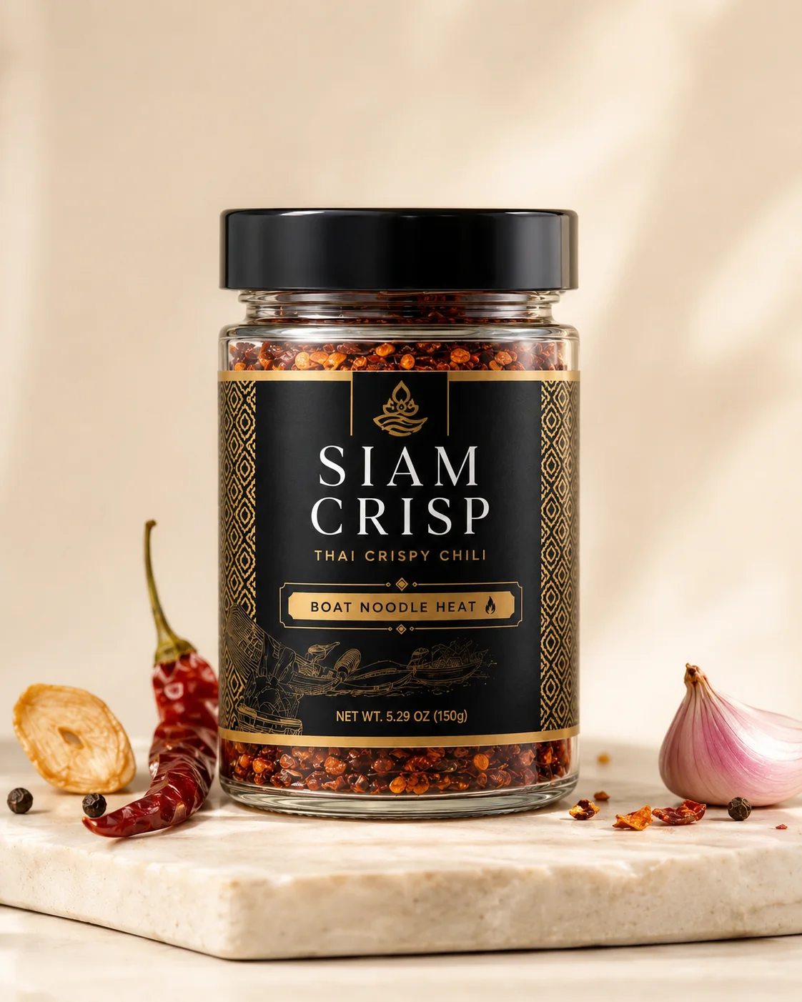 Siam Crisp Boat Noodle Heat jar on stone with dried chili, shallot, garlic, and crispy chili flakes